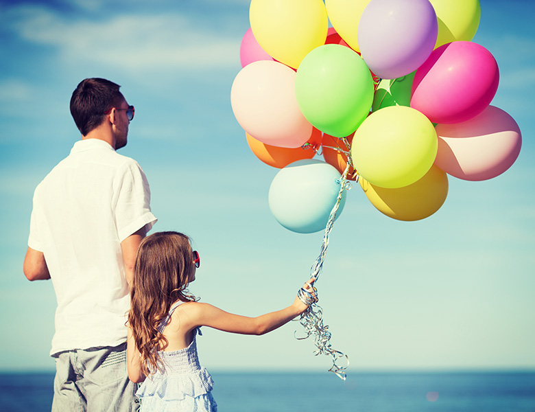 Father and daughter holding balloons. Mindful parenting.